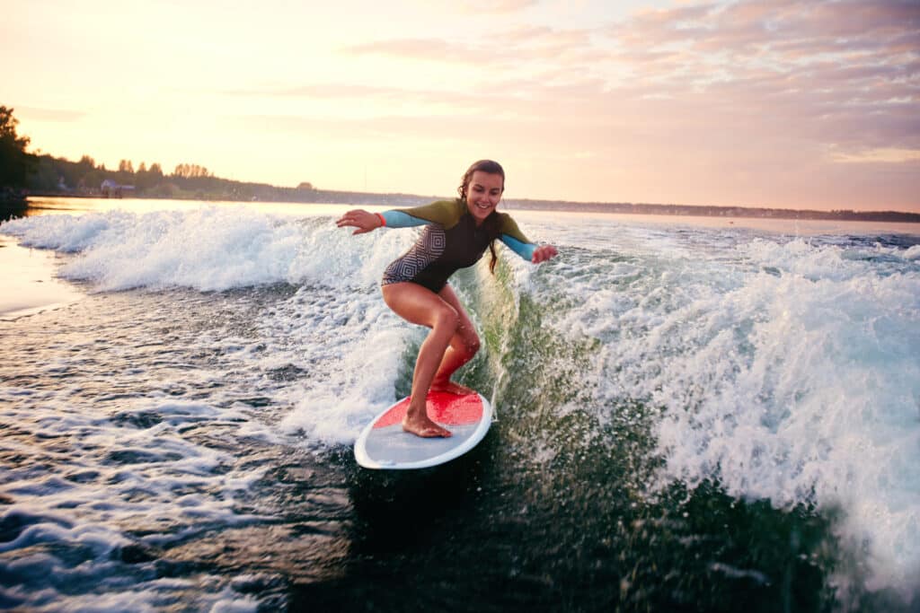 teenager enjoying summer Pige står på surfboard på fjorden