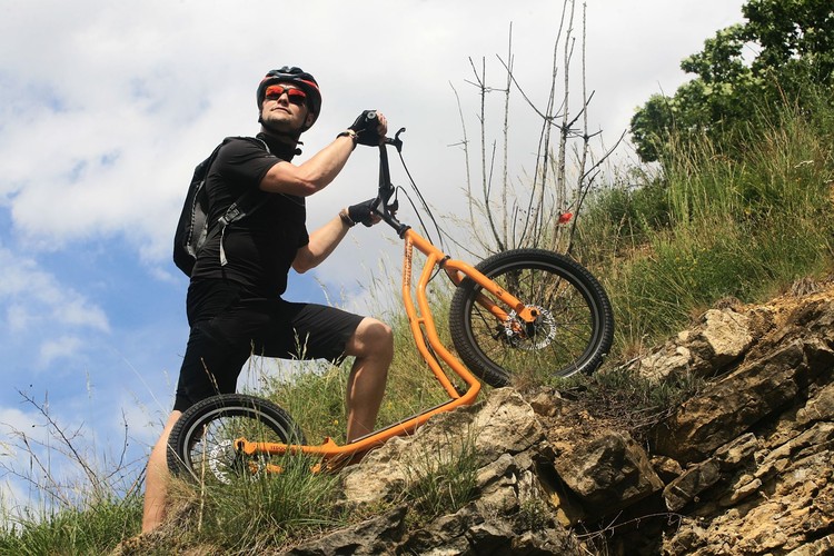Person med løbecykel er på vej op af bakke Person med løbecykel er på vej op af bakke