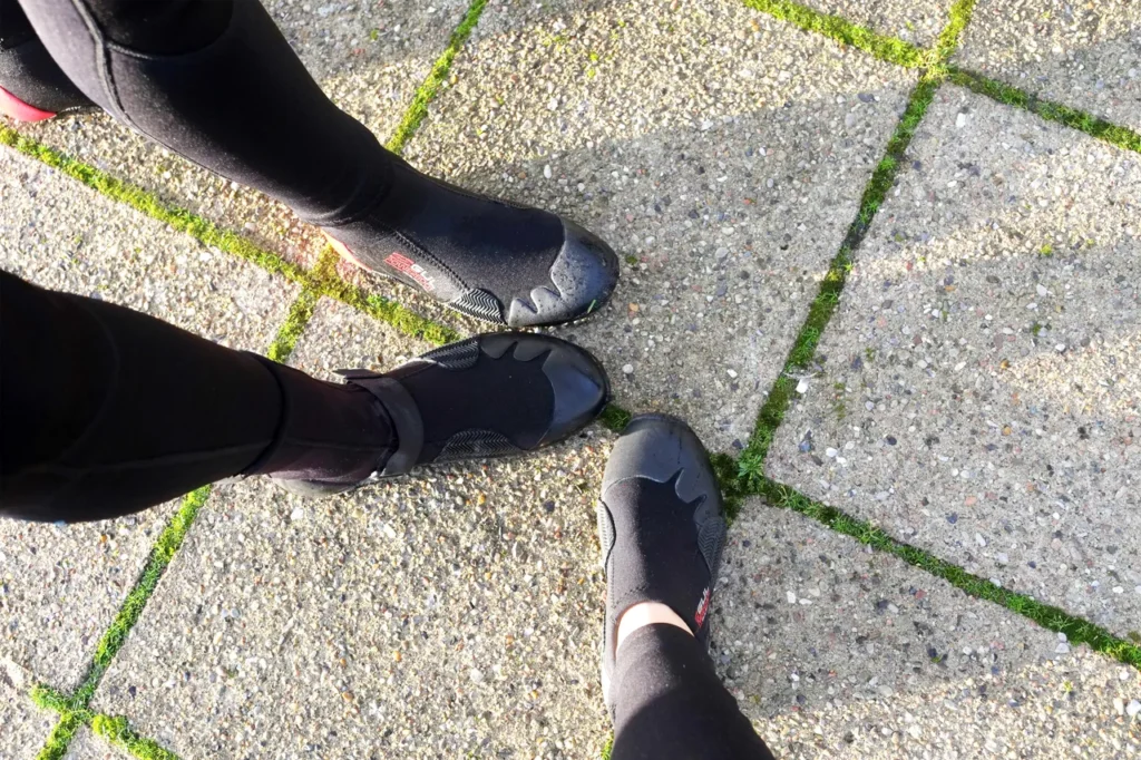 dflf asdk90g ad9s0 90 Tre personer med neoprensko har fødderne inde i en cirkel