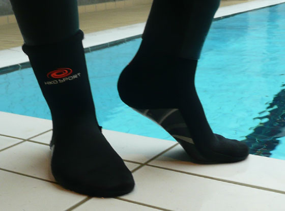 fsd8 dasa8s dsio8 ssa009 Person står med på kanten til poolen med neopren sokker på