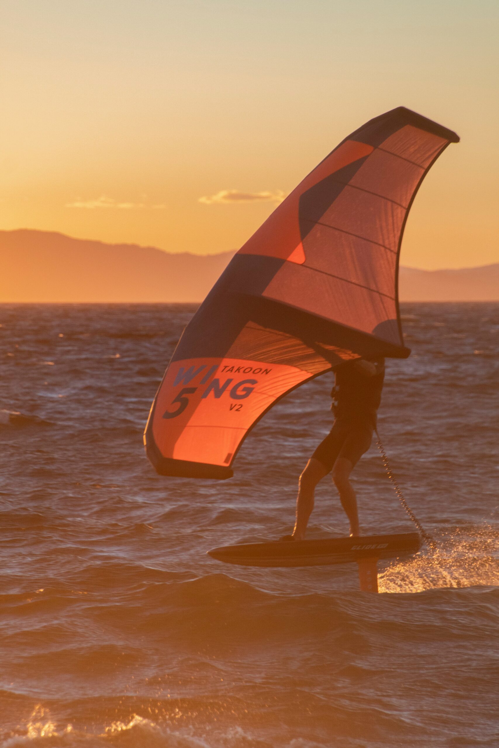 lucie dorne 8z2CDrl7Xbs unsplash scaled Person står på wakeboard i sommer aftensolen.